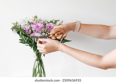 Florist Is Carefully Trimming The Stems Of Purple Flowers With Golden Scissors, Arranging Them In A Glass Vase. Flowers Care Concept. - Powered by Shutterstock