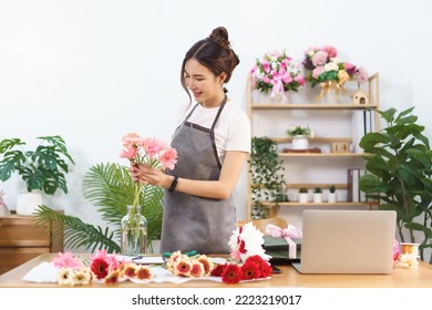 Florist concept, Female florist arranging pink gerbera in vase with happiness at flower shop. - Powered by Shutterstock