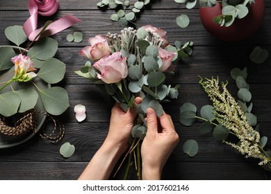 Florist Creating Beautiful Bouquet At Black Wooden Table, Top View