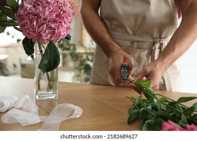 Florist Cutting Flower Stems At Table, Closeup