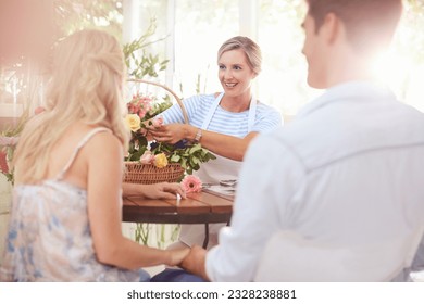 Florist discussing flowers with couple in flower shop - Powered by Shutterstock