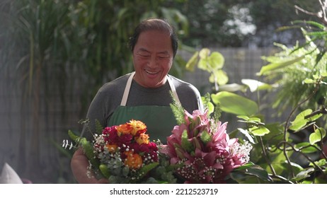 Florist Entrepreneur Holding Bouquet Of Flower Arrangement Ready For Customer Delivery. Male Asian Middle Age Entrepreneur Carries Colorful Roses