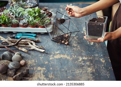 Florist filling a terrarium container with the potting mix