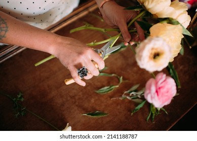 Florist hand trimming flower stems to make an arrangement - Powered by Shutterstock