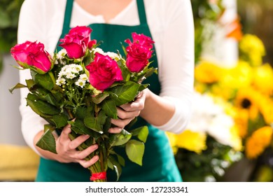 Blumenhändchen mit roten Rosen und Blumenmarkt