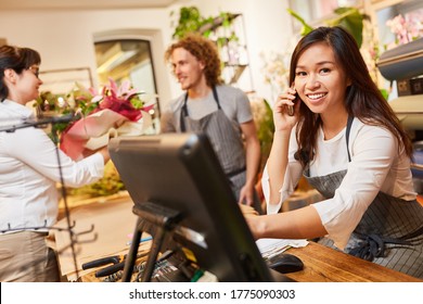 Florist on the phone in the florist takes an order - Shutterstock ID 1775090303