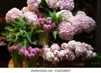 Florist Shop Window. Beautiful Decoration Of Luxurious Pink Hydrangea, Hyacinth, Peony Flowers. Showcase Window Of Floral Shop With Atmospheric Lights. Dark Exquisite Stage Photo. Selective Focus 