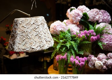 Florist Shop Window. Beautiful Decoration Of Luxurious Pink Hyacinth, Peony Flowers, Fern, Interior Items, Lighting. Showcase Window Of Floral Shop With Atmospheric Lights. Dark Exquisite Stage Photo