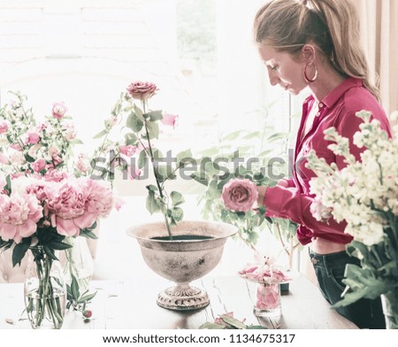 Similar – Woman arranges flower bouquet with roses in vase