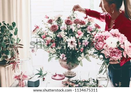 Similar – Woman arranges flower bouquet with roses in vase