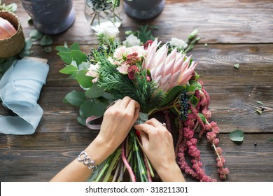 Florist at work: pretty young blond woman making fashion modern bouquet of different flowers - Shutterstock ID 318211301