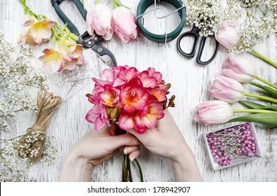 Florist at work. Woman making bouquet of spring freesia flowers - Powered by Shutterstock