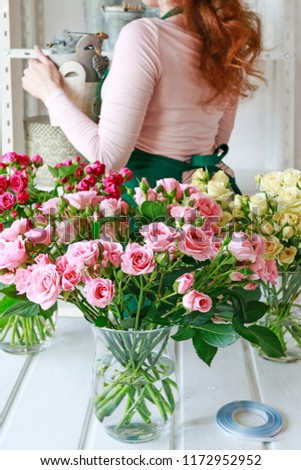 Similar – Woman arranges flower bouquet with roses in vase