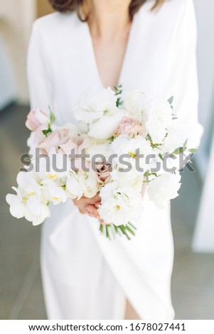  Floristics in the style of fine art in Europe. Light bouquet of peonies and roses. Modern wedding bouquet in the hands of the bride.