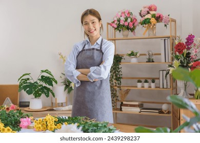 Floristry concept, Woman florist wear apron and stand to smiling with arms crossed in flower shop. - Powered by Shutterstock