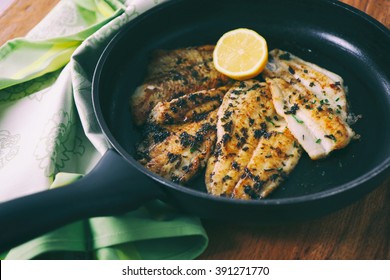 Flounder fillet roasted in a skillet with herbs and lemon butter 