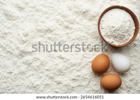 Flour portion and eggs on wheat flour cooking flat lay background with copy-space