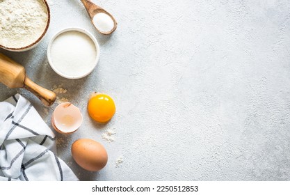 Flour, sugar, eggs and rolling pin at light stone table. Top view with copy space. - Powered by Shutterstock