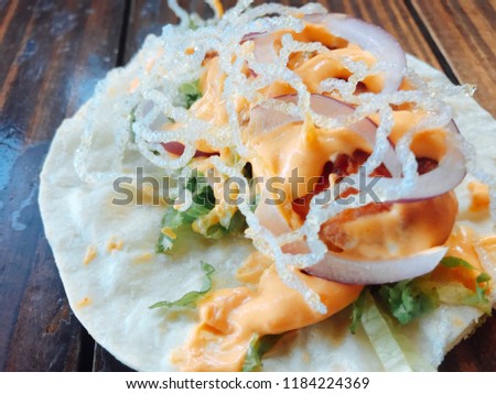 Flour tortilla taco with lettuce, organic tomato and fresh onion with chipotle sauce.