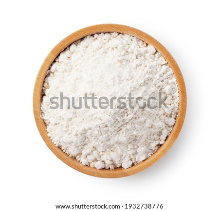 Flour in a wooden bowl set against a white background. View from above