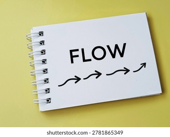 Flow concept with arrows on notepad over yellow background representing process movement workflow and business strategy. 