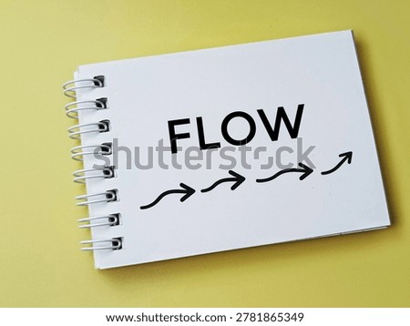 Flow concept with arrows on notepad over yellow background representing process movement workflow and business strategy. 