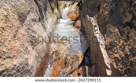 The Flow Of A Fresh, Fresh River Water That Flows Between The Gaps Of Two Large Mountain Rocks