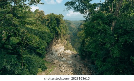 The flow marks the edge of the waterfall and also serves as a channel for lava descending from the mountain; an aerial view reveals how the rocks contribute to the composition of the landscape, framing the river's relatively gentle current.