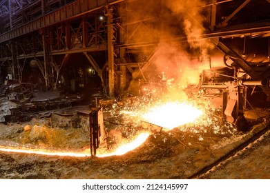 The flow of molten hot metal, molten steel flows along the guide chute. Blast furnace - Shutterstock ID 2124145997
