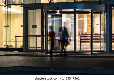  The Flow Of People Passing Through The Revolving Door Of The Modern Office Building At The End Of The Working Day