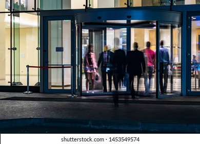  The Flow Of People Passing Through The Revolving Door Of The Modern Office Building At The End Of The Working Day