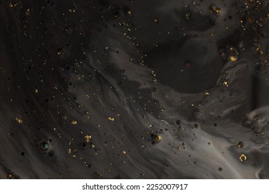 Flow pour oil and acrylic color painting blot. Abstract black and gold glitter texture background.