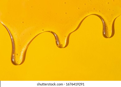 Flow Of Sweet Honey On The Yellow Background With Copy Space