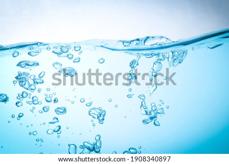 The flow of water creates a splash and the blue waves underwater, and the bubbles naturally flow to the surface. with copy space