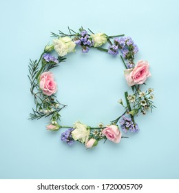 flower arrangement circle of roses, eustoma and lemongrass on blue background, top view, copy space, summer concept