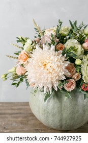 Flower Arrangement In Pumpkin On The Table Of Wooden Planks