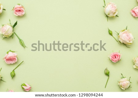 Flower background. Assorted rose border decor. Copy space on palegreen background. Flat lay.