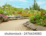 Flower beds and cobblestone walkways in an English garden filled with a variety of colorful flowers
