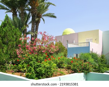 Flower Beds And Palm Trees In The Background Of Architecture On A Clear Sunny Day. Monastir,Tunis.