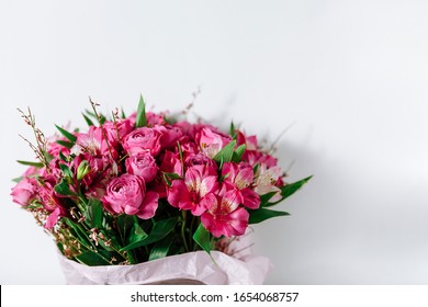 Flower Bouquet Of Pink Roses And Other Mixed Flowers Wrapped In Soft Pink Paper. Copy Space. White Background