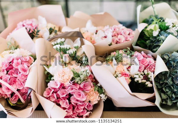 紫陽花 玫瑰 牡丹 月花 桔梗 粉紅色和海綠色製成的桌子上的花店很多花束庫存照片 立刻編輯