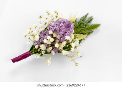 Flower boutonniere decoration for clothes for holidays, anniversaries, weddings. Small bouquet of fresh flowers as an art object on a white background close-up