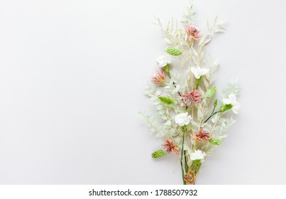 Flower Composition Made Of Dried Light-green Leaves Of Ruscus And White Flowers On Pastel Grey Background. Nature Concept, Copy Space, Flat Lay.