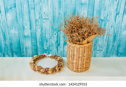 Flower Crown Near Wooden Basket With Dried Flowers On Blue Background.image