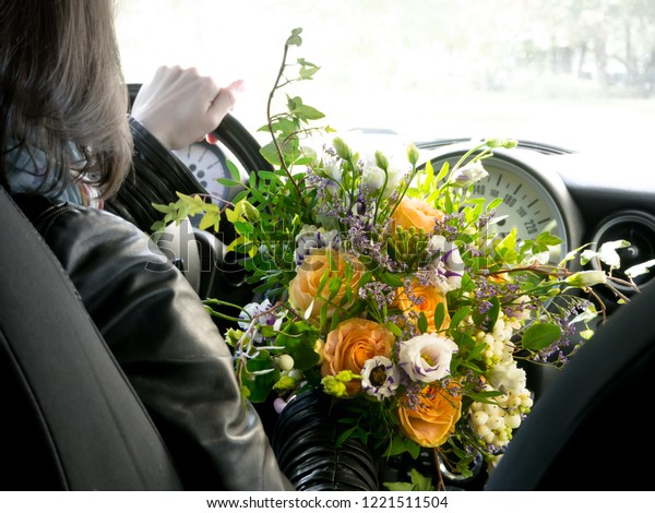 Flower delivery. The driver behind the wheel\
with a bouquet of\
flowers.