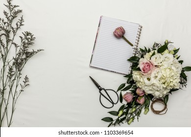 Flower flat lay with notebook and sissors