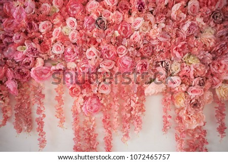 Flower garland on the wall. Dense wall of flowers. Wedding photo zone. Romantic space decor