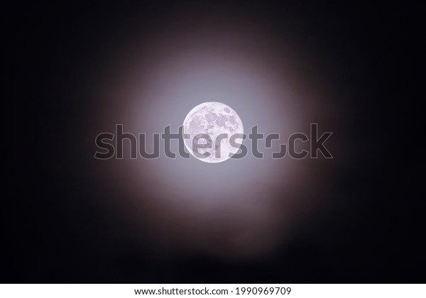 Flower moon, full moon with pink and purple haze\
isolated in black night\
sky