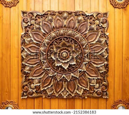 The flower pattern on the wooden carving is installed on the ceiling of the entrance hall in the hotel, front view for the background.