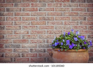 Flower Pot In Front Of A Brick Wall In The Garden